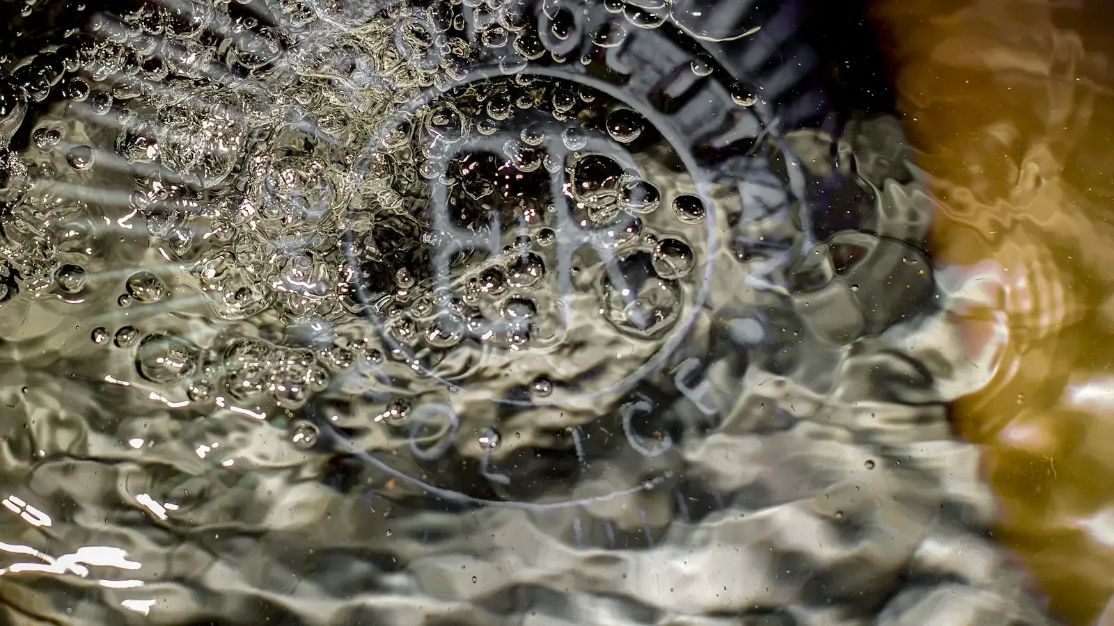 Water swirling and bubbling over a drain strainer